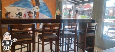 Sente em uma das mesas no Mini Kalzone Guarda do Embaú