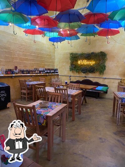 Sente em uma das mesas no Villarejo Cafeteria, Empório e Restaurante