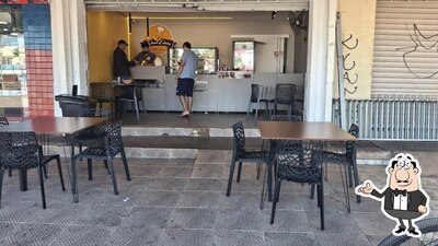 Sente em uma das mesas no Dona Lúcia Salgados Gourmet