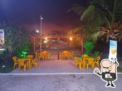 Sente em uma das mesas no RESTAURANTE PÉ NA AREIA